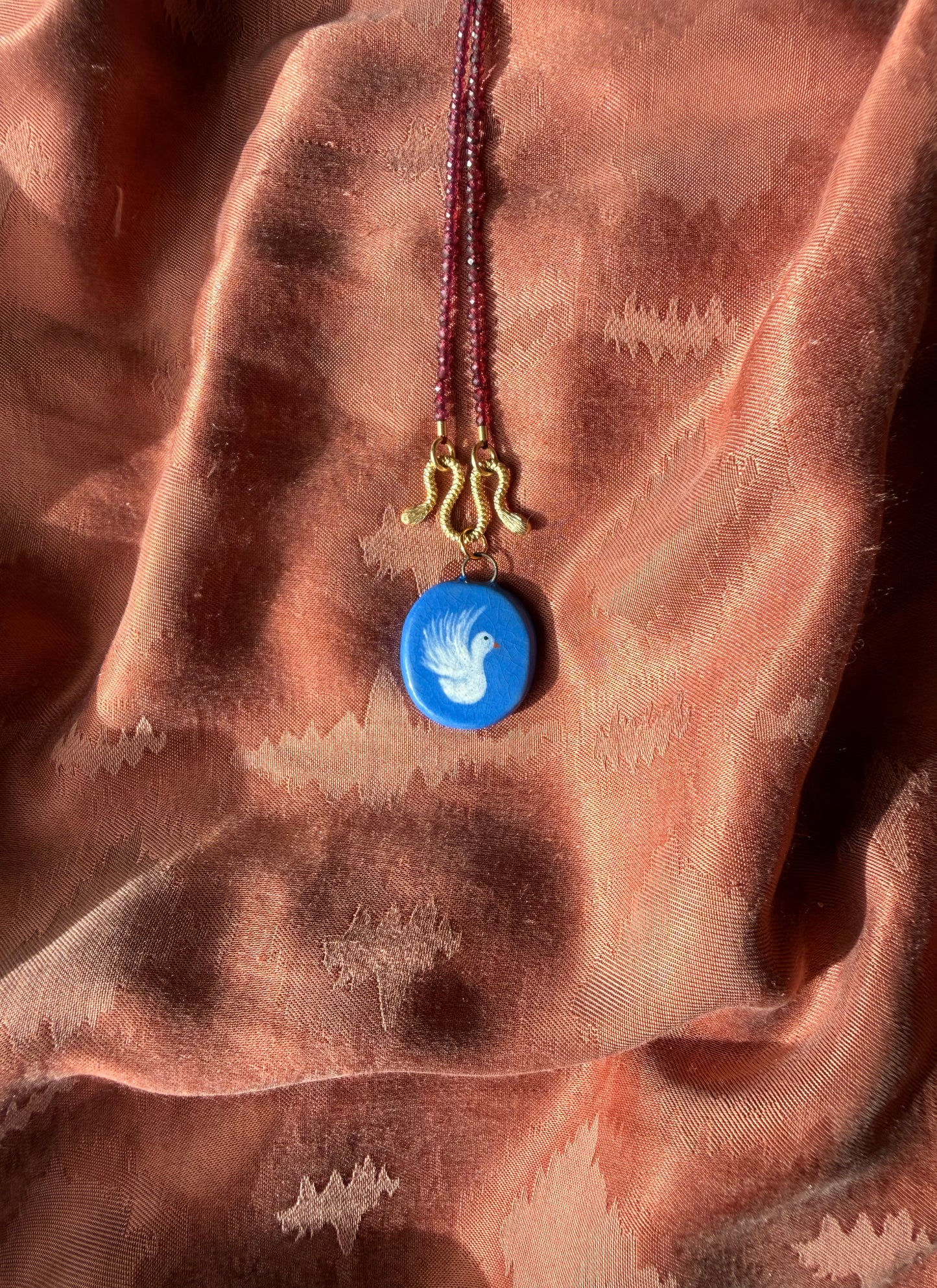 Blauw bedeltje met duifje