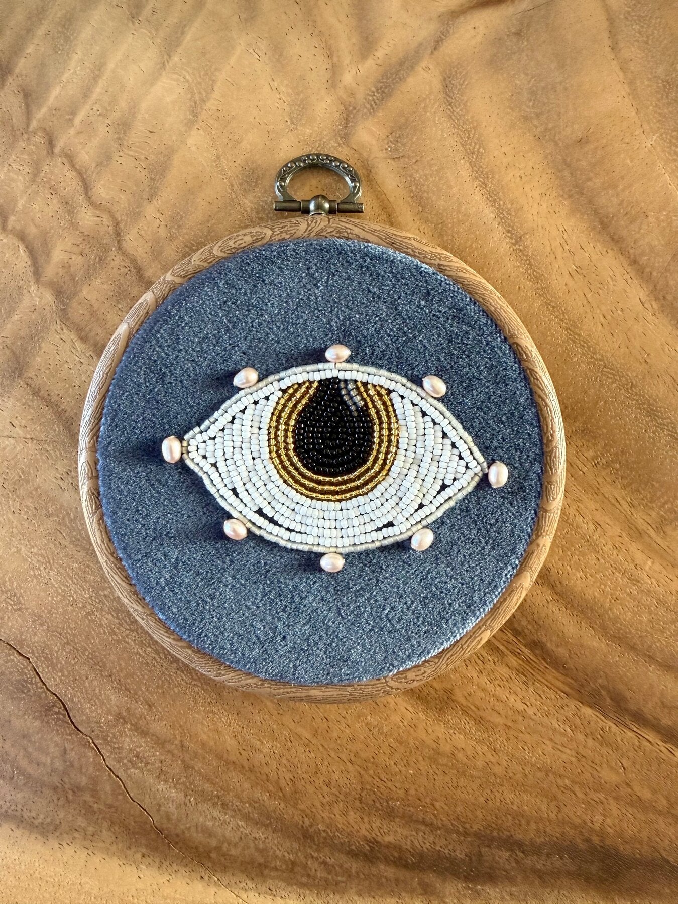 Handgemaakt oog wandhanger van kralen op blauw fluweel met zoetwaterparels en gouden accenten, Amber Nicola
