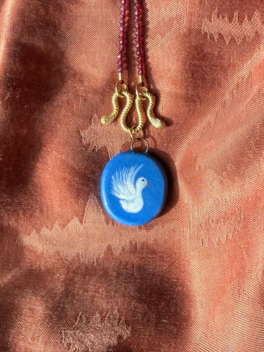 Blauw bedeltje met duifje