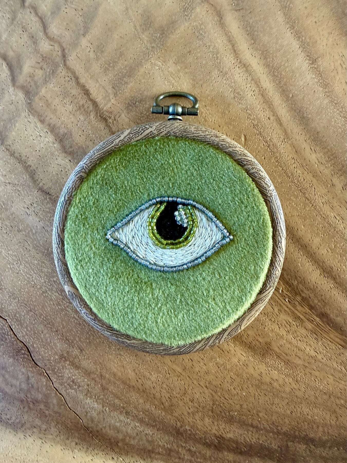 Handgeborduurde oog wandhanger op groen vilt met zaadkralen, in houten borduurring, Amber Nicola
Tags: wandhanger, borduurwerk, oog, evil eye, handgemaakt, vilt, groen, interieur, borduurring, boho, mystiek, cadeau, Amber Nicola